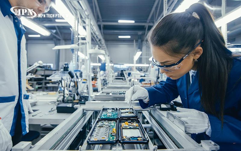 Technician assembling electronics on a production line.