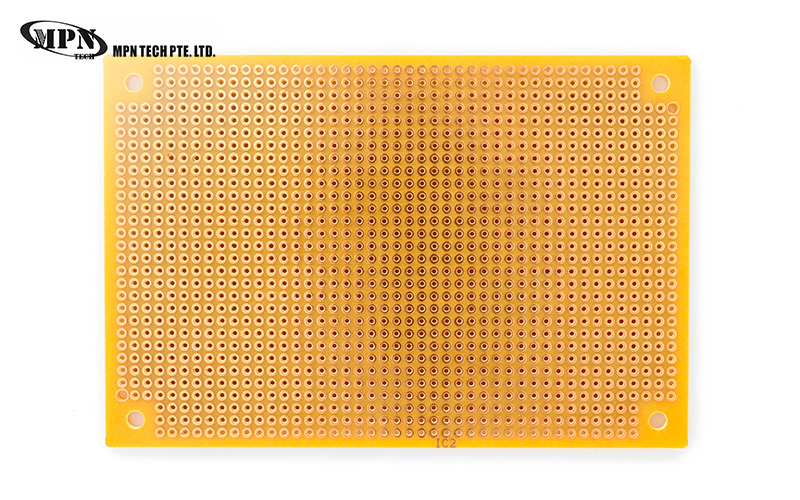 Top-down view of a blank yellow perfboard prototype circuit board.