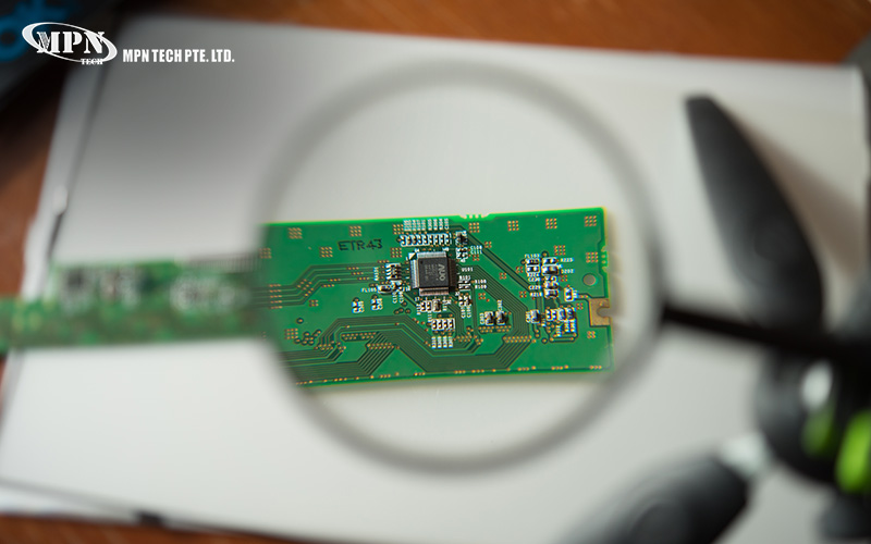 Magnifying glass inspecting circuit board quality for IPC standards compliance