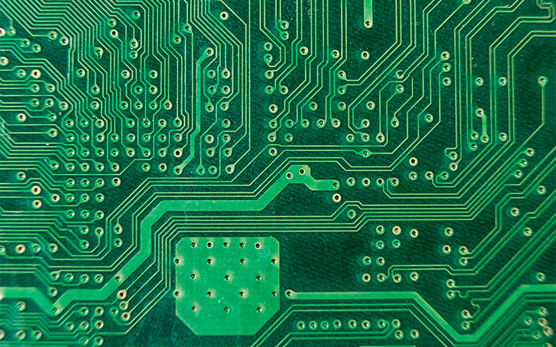 Close-up of intricate PCB trace routing connecting electronic components.