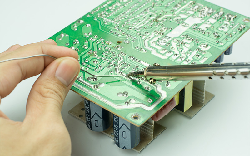 technician soldering joints on a printed circuit board