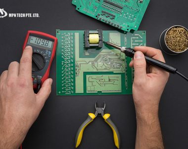 A technician using a soldering iron and multimeter to work on a printed circuit board (PCB).