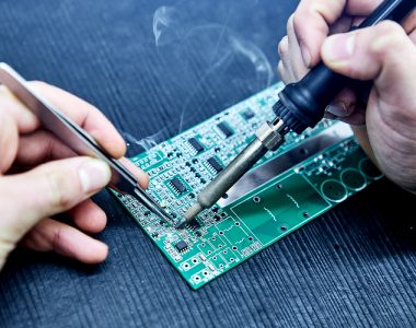 Technician-soldering-components-onto-printed-circuit-board-assembly